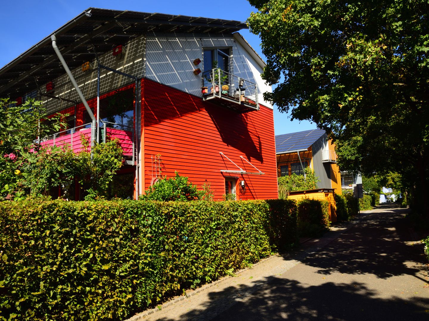 Contemporary solar powered house in Freiburg surrounded by lush gardens, showcasing eco friendly architecture.